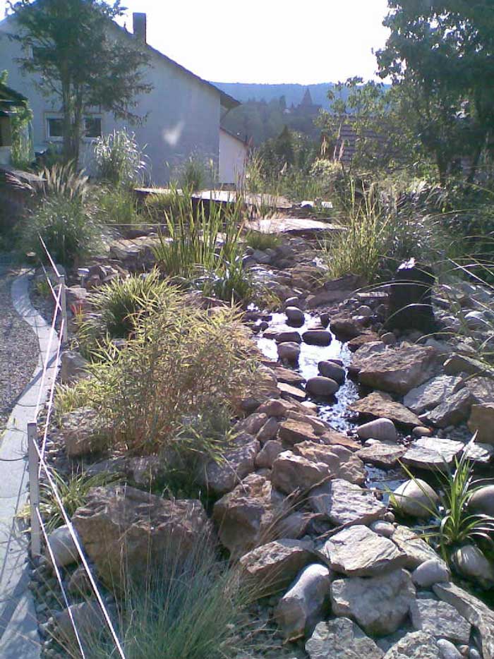 Teichbau im Garten mit Natursteine und Bachlauf