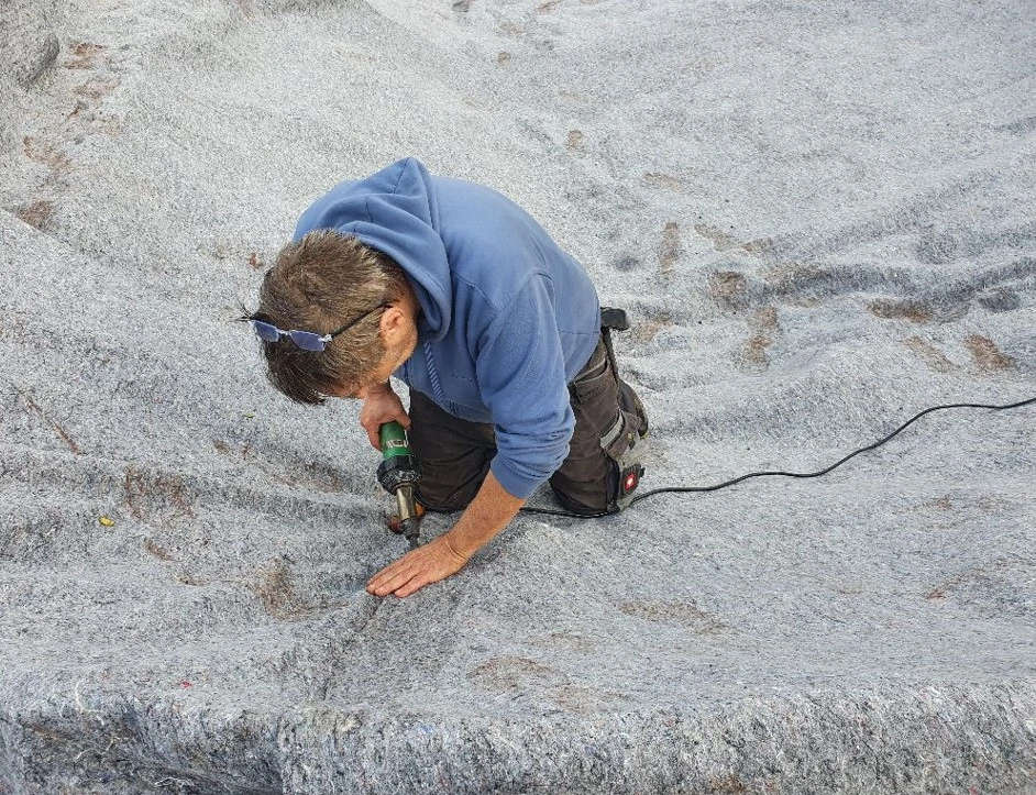 Teichvlies wird zum schutz der Teichfolie verlegt