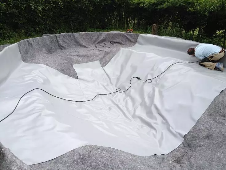 Hier wird eine PVC Teichfolie faltenarm in einen Gartenteich verschweißt. 